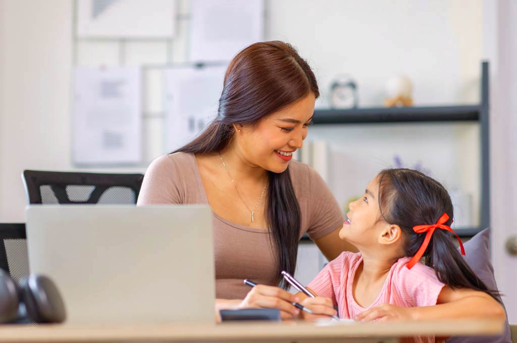 Mother teaching her girl, both have long brown hair